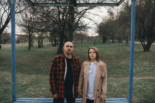 Portrait of a young white couple looking at the camera with suspicion. Outdoors