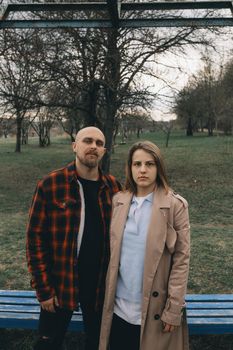 Portrait of a young white couple looking at the camera with suspicion. Outdoors