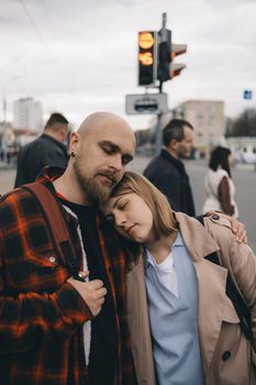 loving couple standing wearily in the arms of the city ith eyes clossed