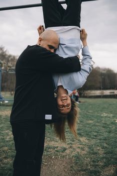 man and woman having fun on the playground in the park