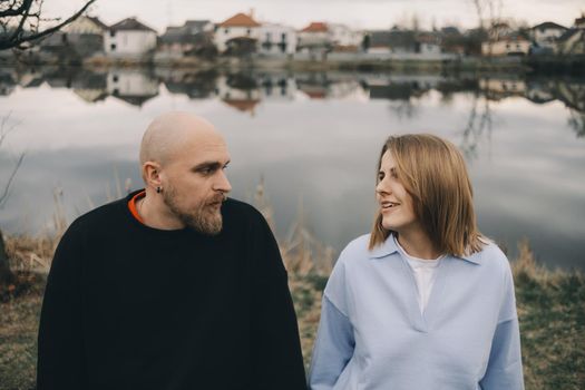 Portrait of a young white couple looking on each other with suspicion. Outdoors