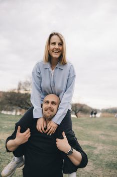 man carries a woman in his arms in the park and they have fun and happy