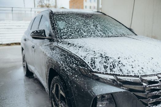 Automatic car wash in action. Great black car in the foam