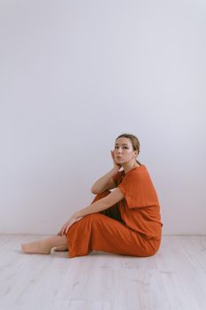 Portrait of young caucasian woman in red cloth. Dreamy