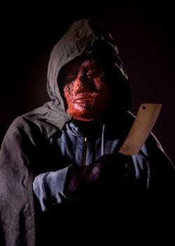 Scary killer in mask and hoodie holding knife