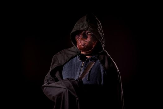 Scary killer in mask and hoodie holding knife