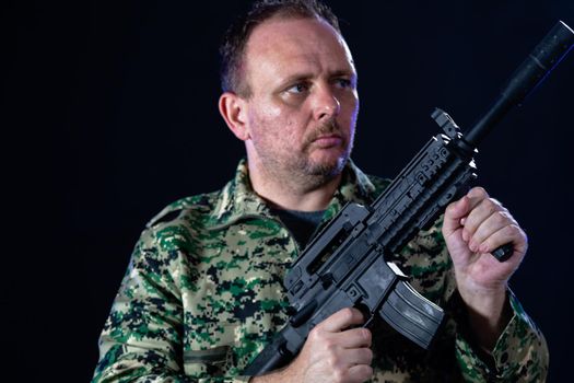 Soldier in army fatigues holding assault rifle