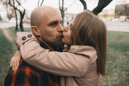 Loving couple embrace with each other. Tree on background. Hipster