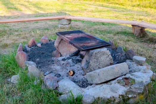 View of the stone-enclosed bonfire with benches. Outdoor recreation