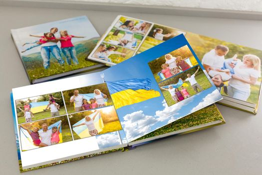 on white table open photobook from photo shoot of family with ukraine flag.