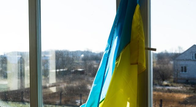 Support Ukraine. Ukrainian flag on the window. Place for text