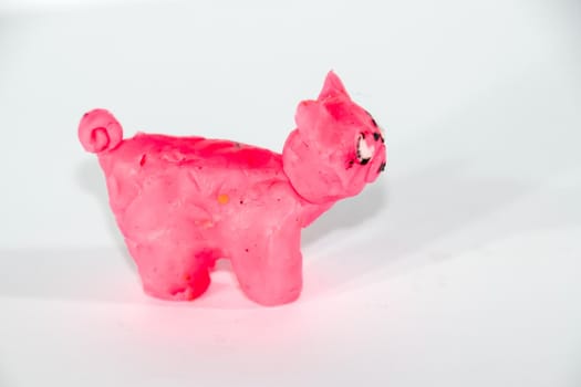 Plasticine piglet. Toys made of plasticine on a white background.