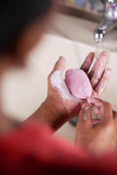 young man washing hands with soap warm water.