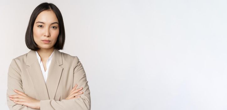 Confident female entrepreneur, asian business woman standing in power pose, professional business person, cross arms on chest, standing over white background.