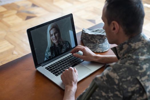 Soldier works on his laptop