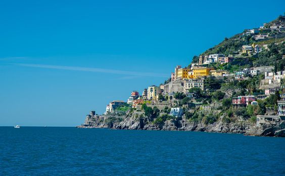 Amalfi Coast Italy photographed from the ferryboat on a sunny day with colourful houses visible on the coast 2022 april 15