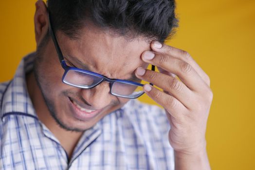 Young man frustrated and suffering headache, close up.