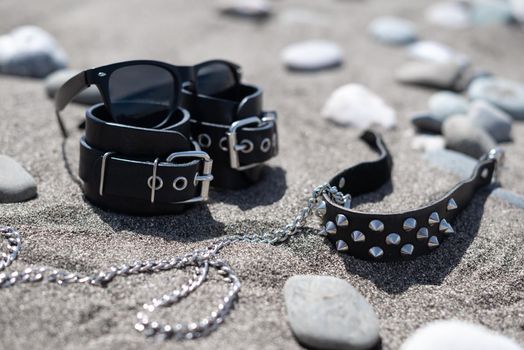 leather handcuffs for bdsm sex toys on a sandy beach