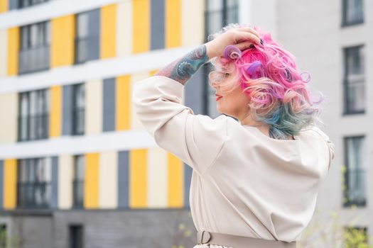 Portrait of a middle-aged woman with multi-colored hair walks on the streets of the city