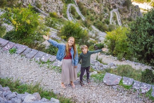 Mother and son travellers enjoys the view of Kotor. Montenegro. Bay of Kotor, Gulf of Kotor, Boka Kotorska and walled old city. Travel with kids to Montenegro concept. Fortifications of Kotor is on UNESCO World Heritage List since 1979.