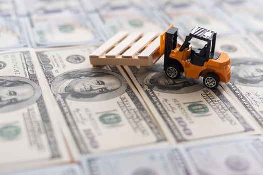 one hundred dollar bills and a toy excavator.