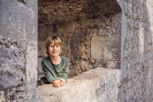 Boy tourist enjoying Colorful street in Old town of Kotor on a sunny day, Montenegro. Travel to Montenegro concept.