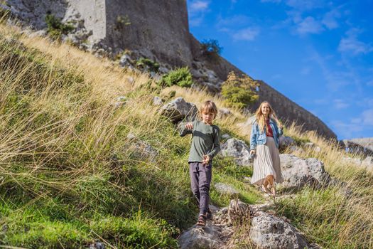 Mother and son travellers enjoys the view of Kotor. Montenegro. Bay of Kotor, Gulf of Kotor, Boka Kotorska and walled old city. Travel with kids to Montenegro concept. Fortifications of Kotor is on UNESCO World Heritage List since 1979.