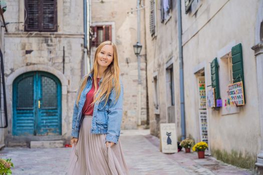 Woman tourist enjoying Colorful street in Old town of Kotor on a sunny day, Montenegro. Travel to Montenegro concept.