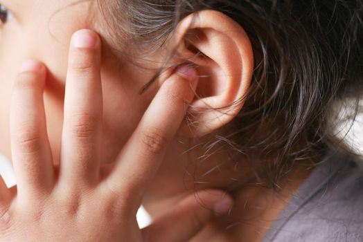 child girl having ear pain touching his painful ear ,.