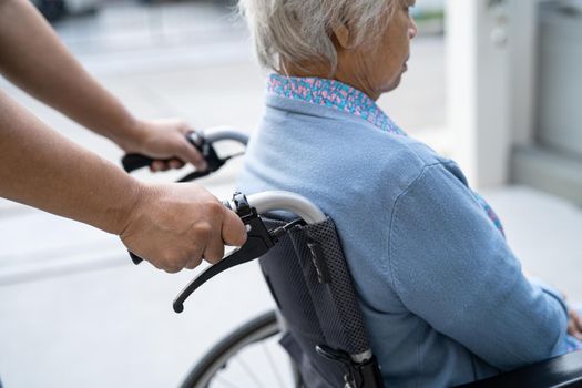 Caregiver help and care Asian senior or elderly old lady woman patient sitting on wheelchair at nursing hospital ward, healthy strong medical concept