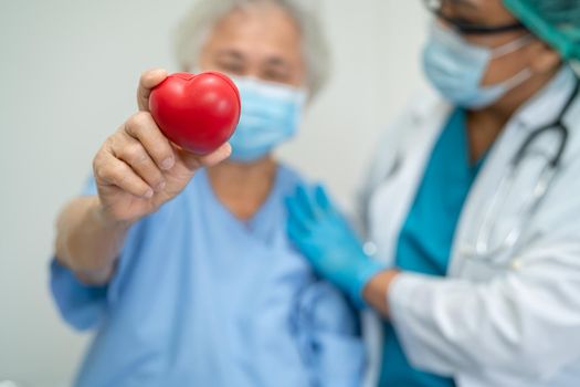 Doctor give red heart to Asian senior or elderly old lady woman patient, healthy strong medical concept