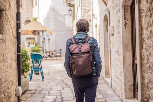 Man tourist enjoying Colorful street in Old town of Kotor on a sunny day, Montenegro. Travel to Montenegro concept.