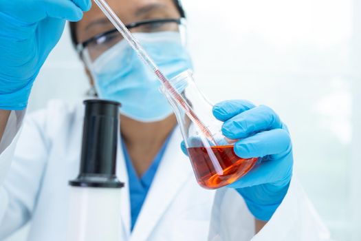 Asian scientist biochemist or microbiologist working research with a microscope in laboratory. For protect outbreak Coronavirus Covid19, bacteria and germs.