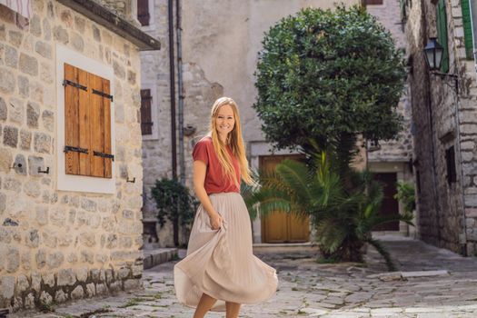 Woman tourist enjoying Colorful street in Old town of Kotor on a sunny day, Montenegro. Travel to Montenegro concept.