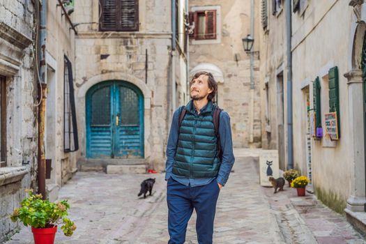 Man tourist enjoying Colorful street in Old town of Kotor on a sunny day, Montenegro. Travel to Montenegro concept.