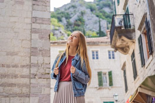 Woman tourist enjoying Colorful street in Old town of Kotor on a sunny day, Montenegro. Travel to Montenegro concept.