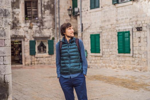 Man tourist enjoying Colorful street in Old town of Kotor on a sunny day, Montenegro. Travel to Montenegro concept.