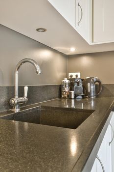 Marble sink and metal faucet in a cozy kitchen close-up