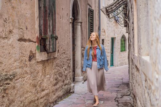 Woman tourist enjoying Colorful street in Old town of Kotor on a sunny day, Montenegro. Travel to Montenegro concept.