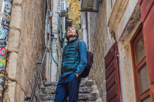 Man tourist enjoying Colorful street in Old town of Kotor on a sunny day, Montenegro. Travel to Montenegro concept.