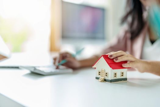 Entrepreneurs, business owners, accountants, real estate agents, focusing on table top home models with women using home equity budget calculators to assess their financial risks