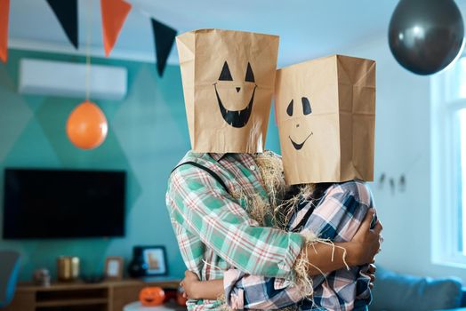 Shot of a young couple with paper bags over their heads at home.