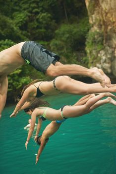 Cropped shot of a group of young friends jumping into the ocean.