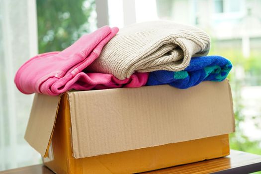 Clothes donations in cardboard box for volunteer.