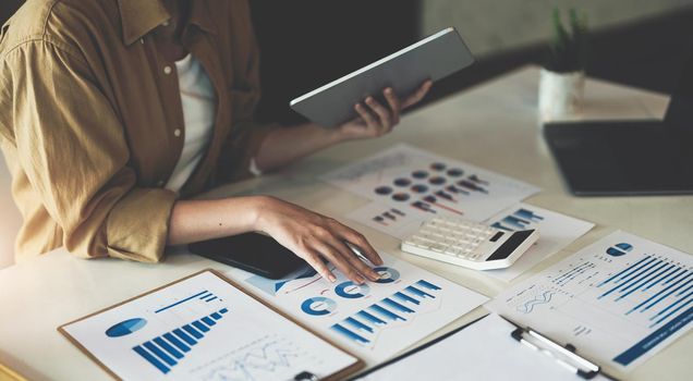 Business or accountant woman analysis turnover with graph chart report and use laptop computer for analysis data.