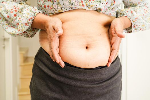 Asian woman show fat belly big size overweight and obesity at office.