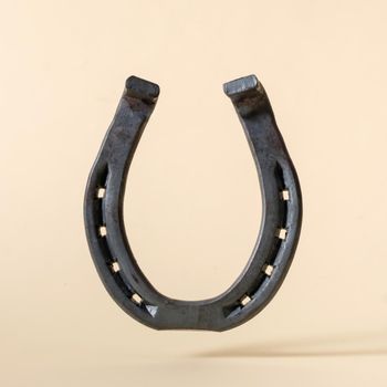 Horseshoe iron on beige background concept of american wild west and rural rodeo or good luck.