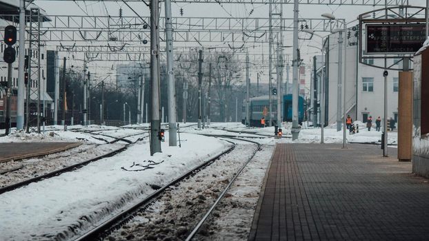 The train arrives at the passenger platform in Minsk on a winter day . High quality photo