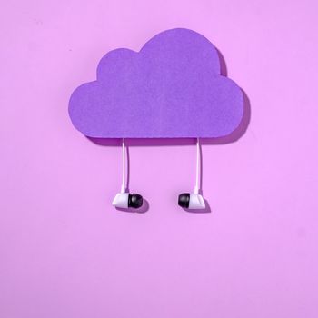 Purple data storage cloud and headphones concept of internet online information and listening to music. Minimal digital technology concept.
