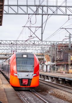 April 1, 2022, Moscow Russia. Modern high-speed train moves fast along the platform. People are waiting for the train at the station, public transport.